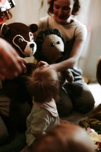 A loving family moment with a child and plush toys indoors, creating warmth and joy.